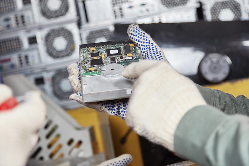 Computer hard disk destruction Computer hard disk being held in gloved hand being readied for secure destruction