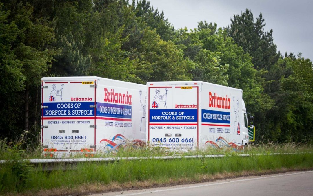 A pair of Britannia Alan Cook removals lorries passing each other on the open road