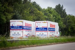 A pair of Britannia Alan Cook removals lorries passing each other on the open road