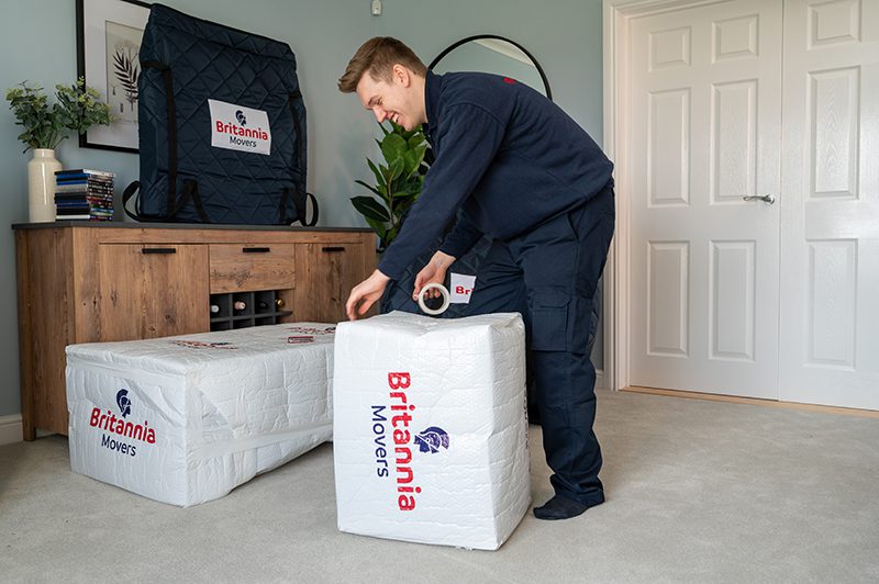 Britannia Alan Cook Removals & Storage team member securely packing furniture in padded removal covers