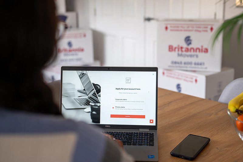 Young woman looking at the website of Britannia Alan Cook Removals & Storage foreign exchange partners, IFX a leading foreign exchange and payments consultancy