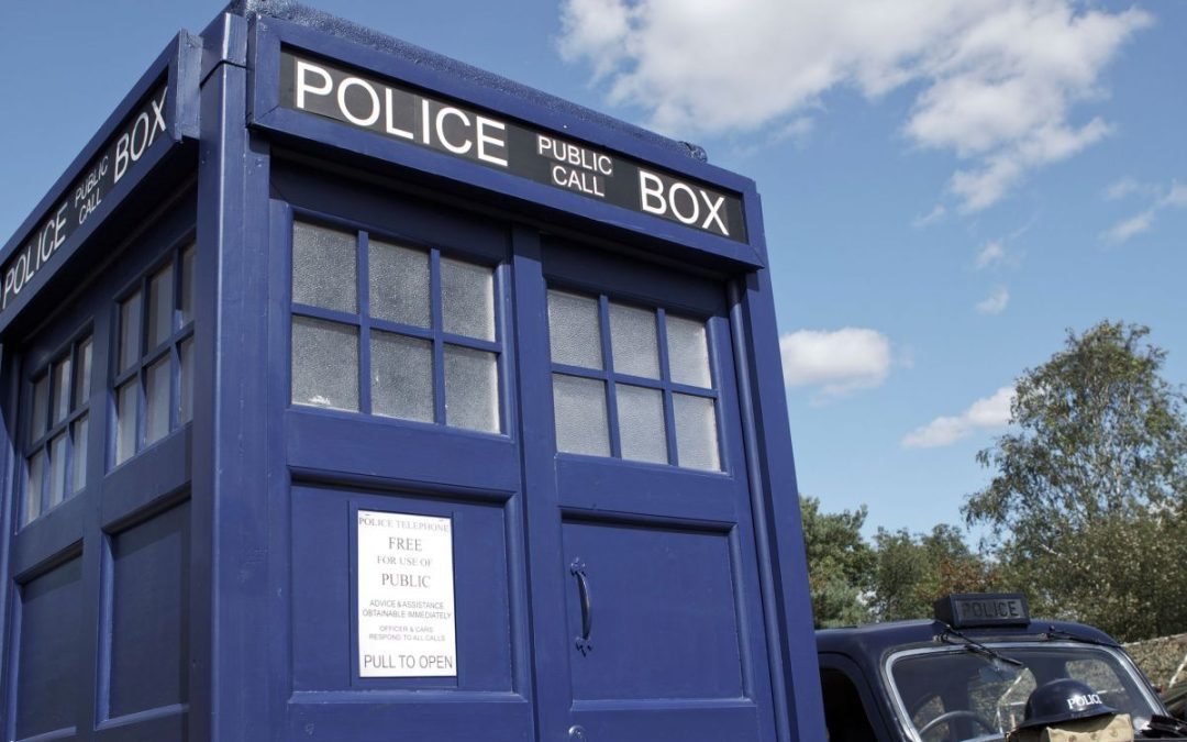 Doctor Who Police Call Box prop next to a vintage Police car