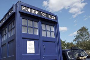 Doctor Who Police Call Box prop next to a vintage Police car