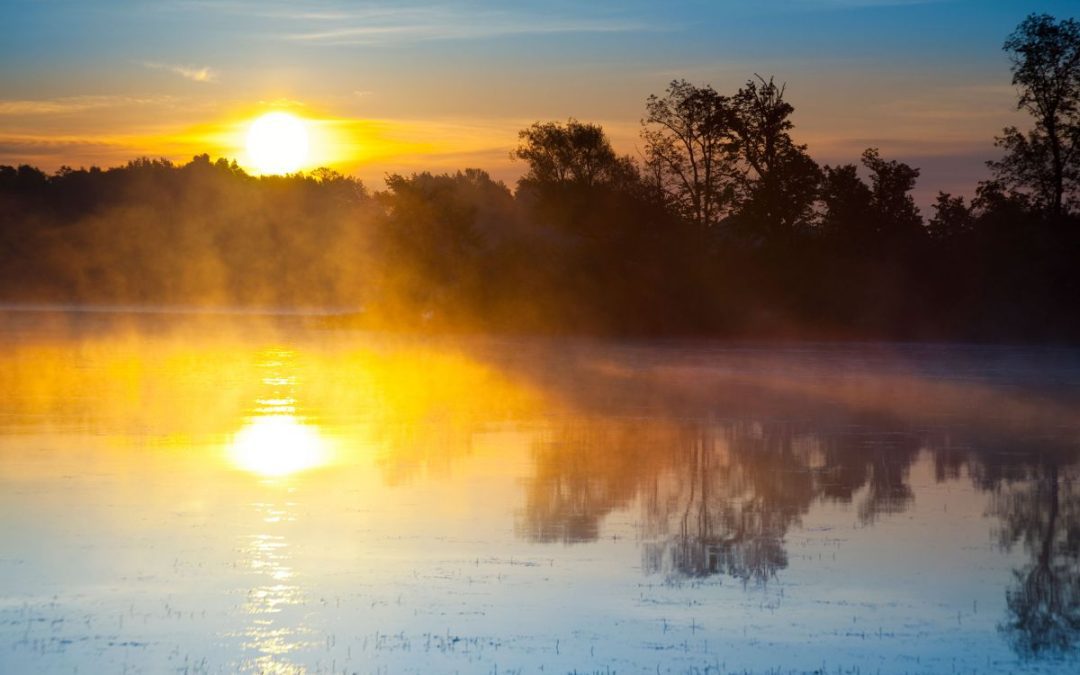 A misty morning sunrise over a lake