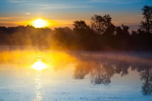 A misty morning sunrise over a lake