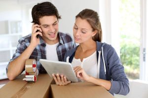 A couple checking our details on a tablet and talking on a mobile phone