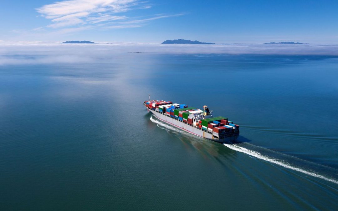Large container ship fully laden with shipping containers sailing on a calm ocean