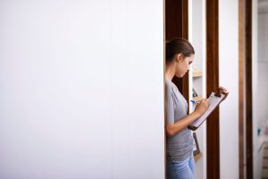 A lady writing moving notes on a clipboard