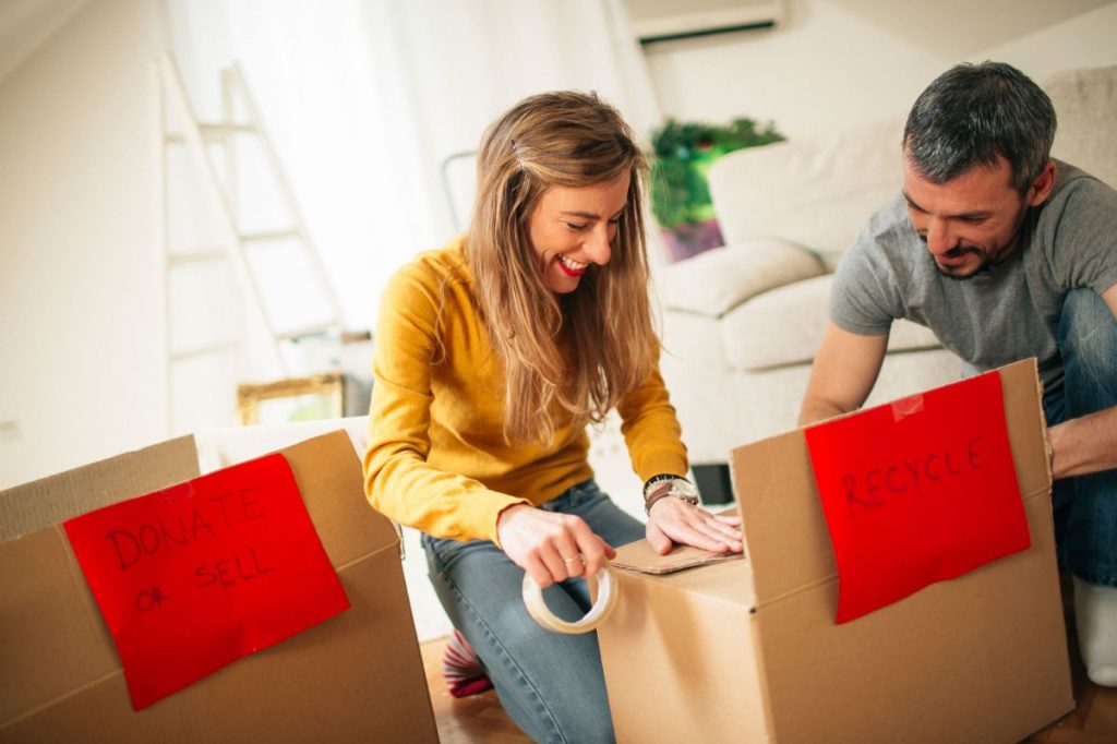 Smiling couple busy packing boxes before a house move