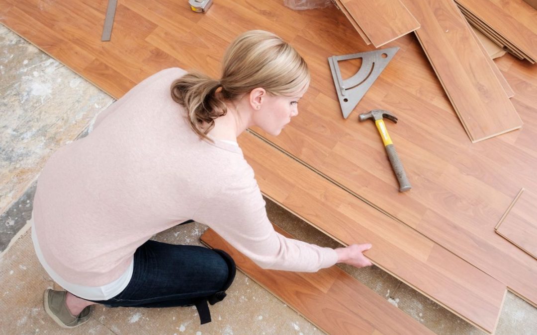 A lady putting together sections of laminated wooden flooring