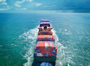 A fully laden container ship heading out on the open ocean