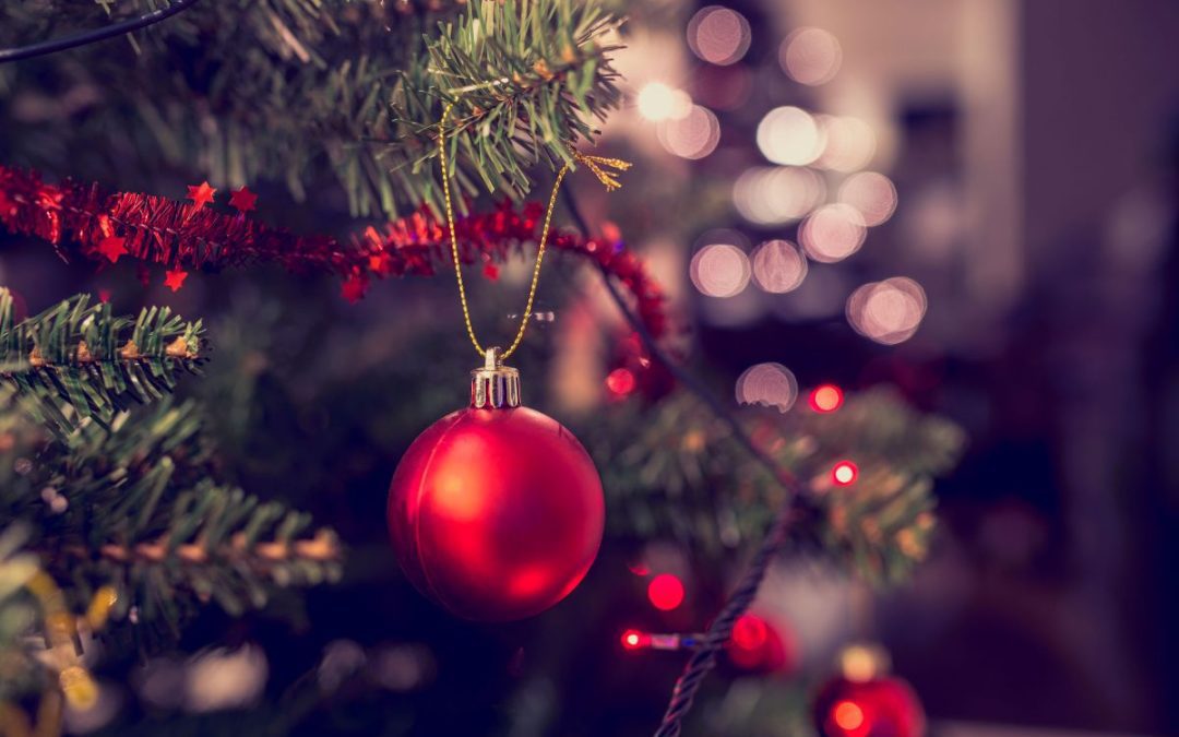 A Christmas Tree with lights, tinsel and a red bauble