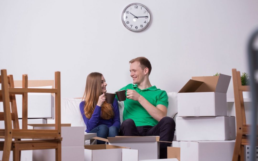 A couple sat with cups of coffee celebrating a house move