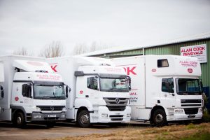A row of Alan Cook Removals specialist removal lorries in front of the Loddon storage facility