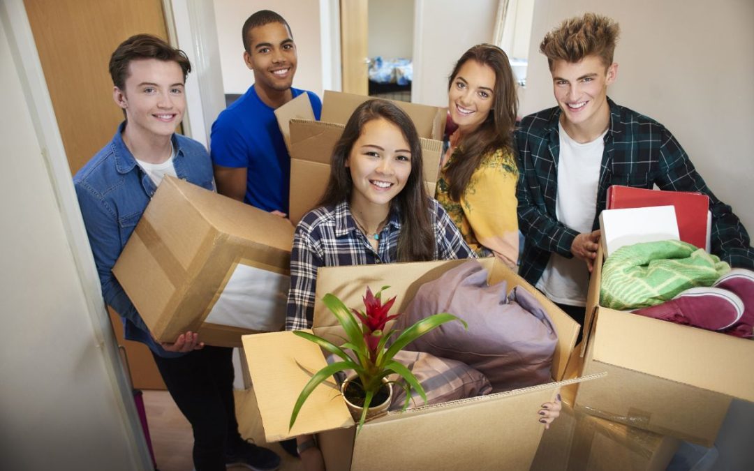 A group of students with boxes full of their personal belongings moving into their new student accommodation