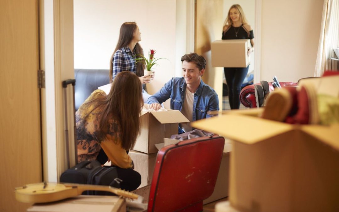 A group of students unpacking their belonging from cardboard boxes in their new student accommodation