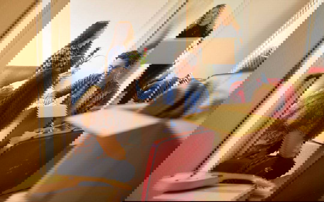 A group of students unpacking their belonging from cardboard boxes in their new student accommodation