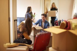 A group of students unpacking their belonging from cardboard boxes in their new student accommodation