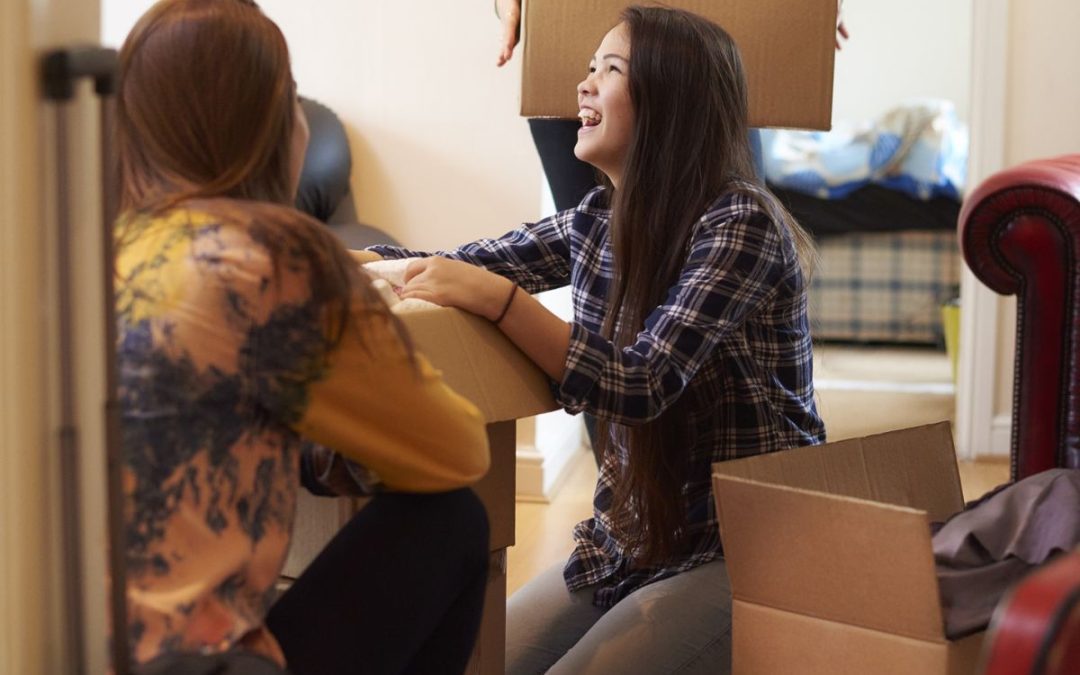 A group of students unpacking their belonging from cardboard boxes in their new student accommodation