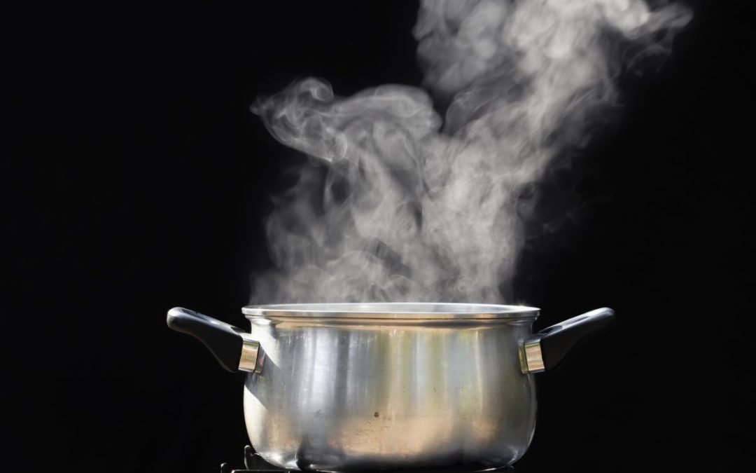 A boiling pan of water with plenty of steam