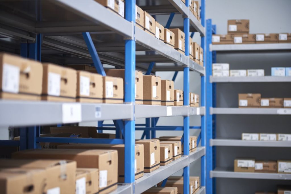 Warehouse metal shelving with lots of neatly labelled and positioned cardboard boxes