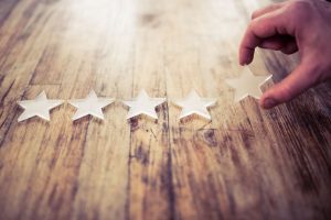 A row of perspex stars lined up on a rustic distressed wooden table