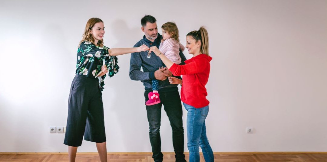 An estate agent handing over keys to a family for their new home