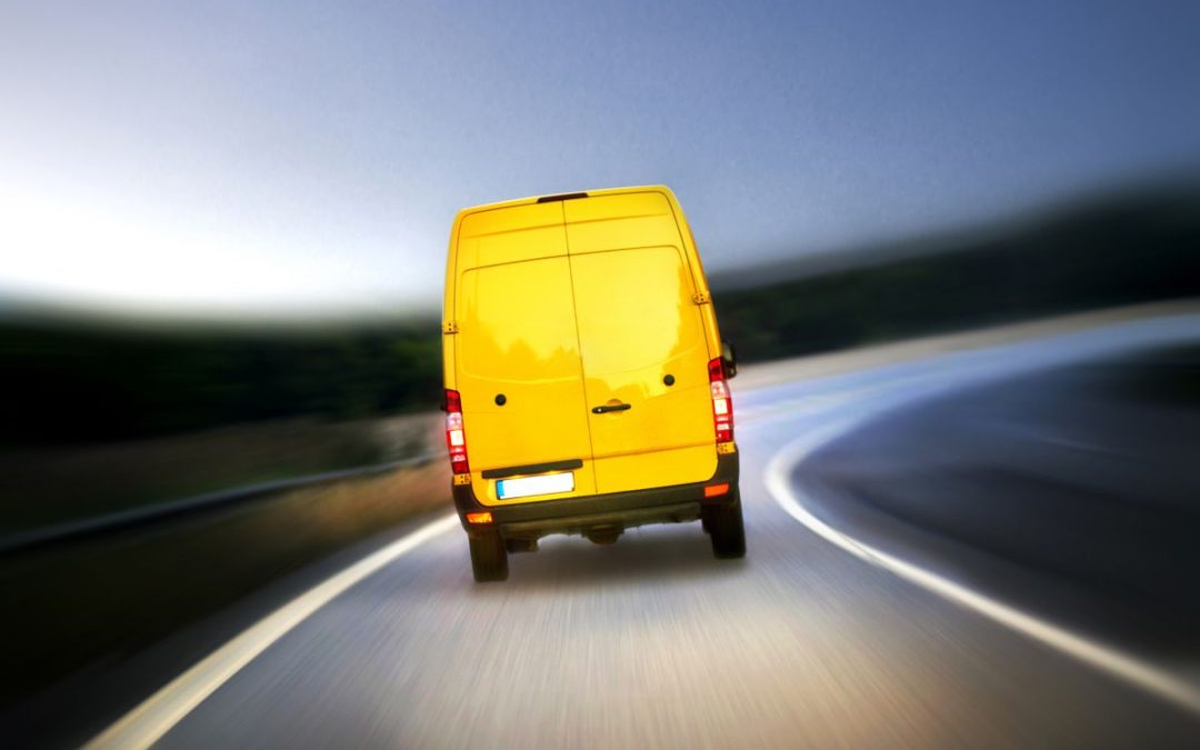 A bright yellow removals van on a slip road in the early hours of the morning