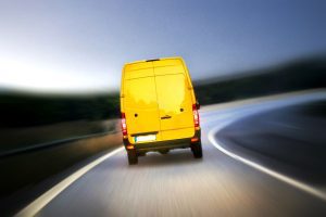 A bright yellow removals van on a slip road in the early hours of the morning