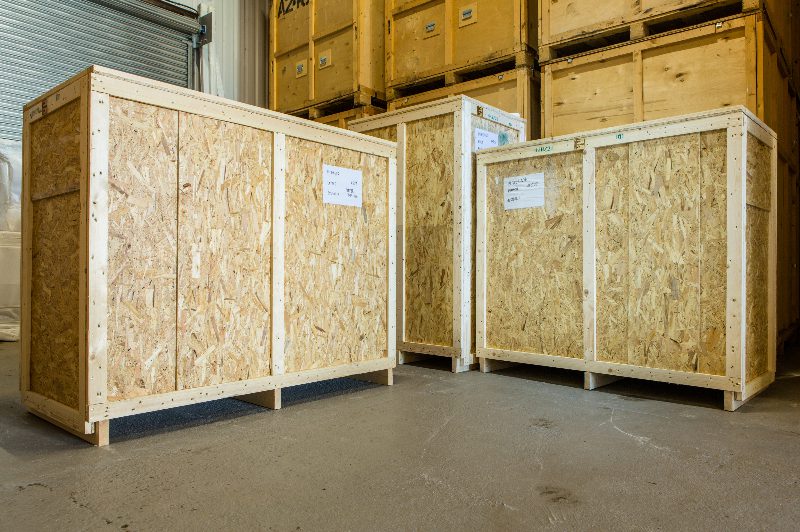 Wooden storage crates about to be unloaded from a Britannia Alan Cook Removals & Storage lorry at a customers new home