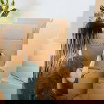 Woman labeling a cardboard box with the word "clothes".